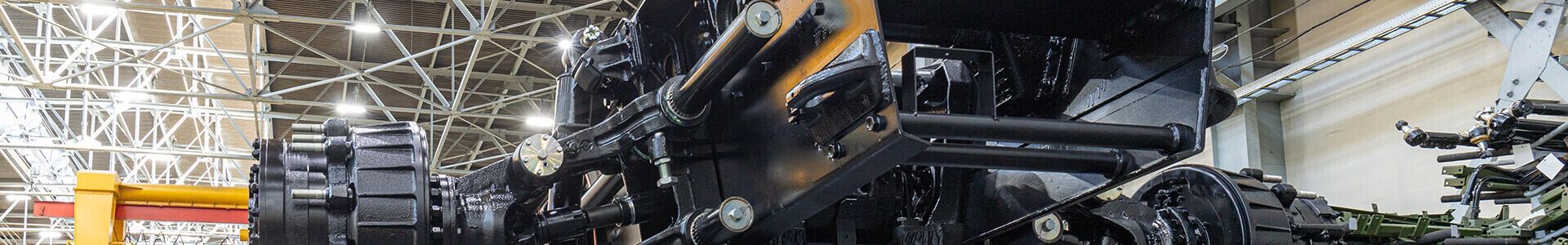A large black and yellow machine in a factory, with appropriate lighting for precision manufacturing in the defence industry