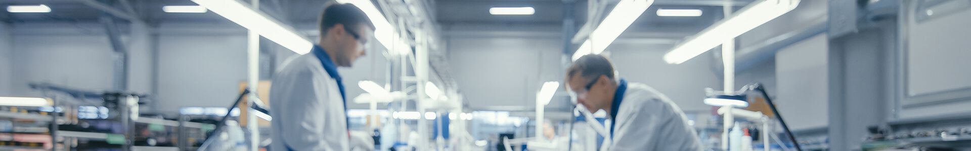 Two men in lab coats are working in a state-of-the-art laboratory on the production of electronic components