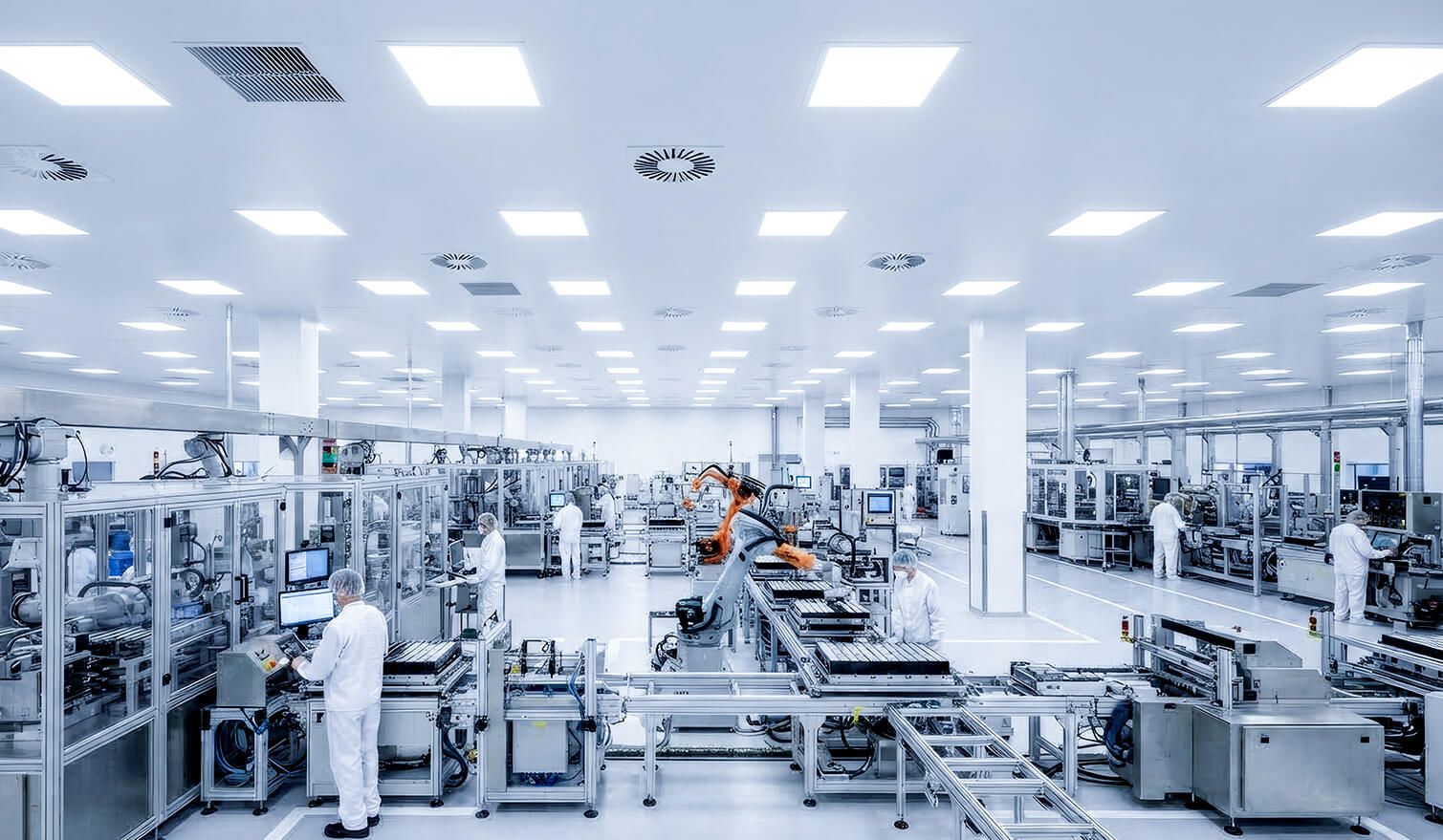 A factory with staff operating machinery in a cleanroom, ensuring controlled conditions for the manufacture of electronic components | Lumedic