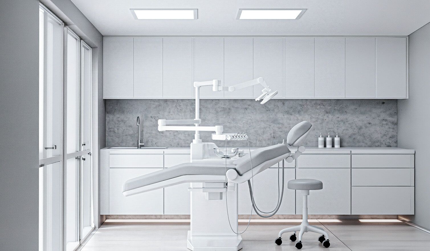 The interior of a dental surgery with white walls and a dental chair set up for dental procedures | Lumedic