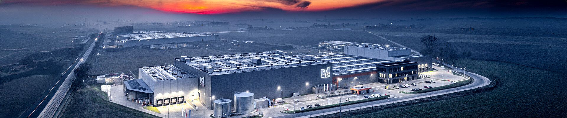Zakład produkcyjny i magazyn oświetlone nocą – instalacja oświetlenia LED Lena Lighting