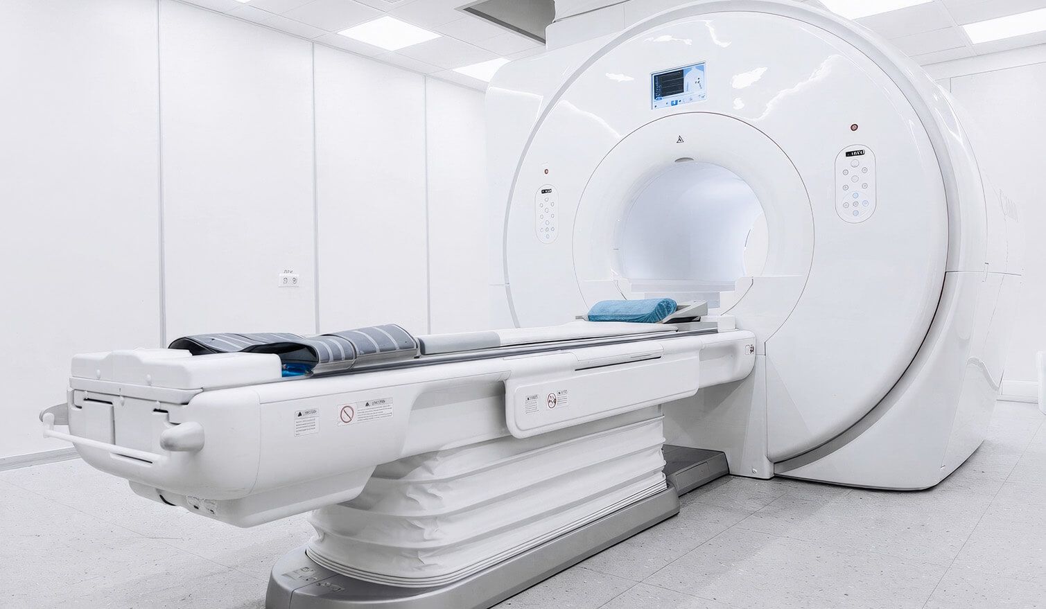A white room housing an MRI scanner, featuring a Lumedic lamp that creates calm and functional lighting